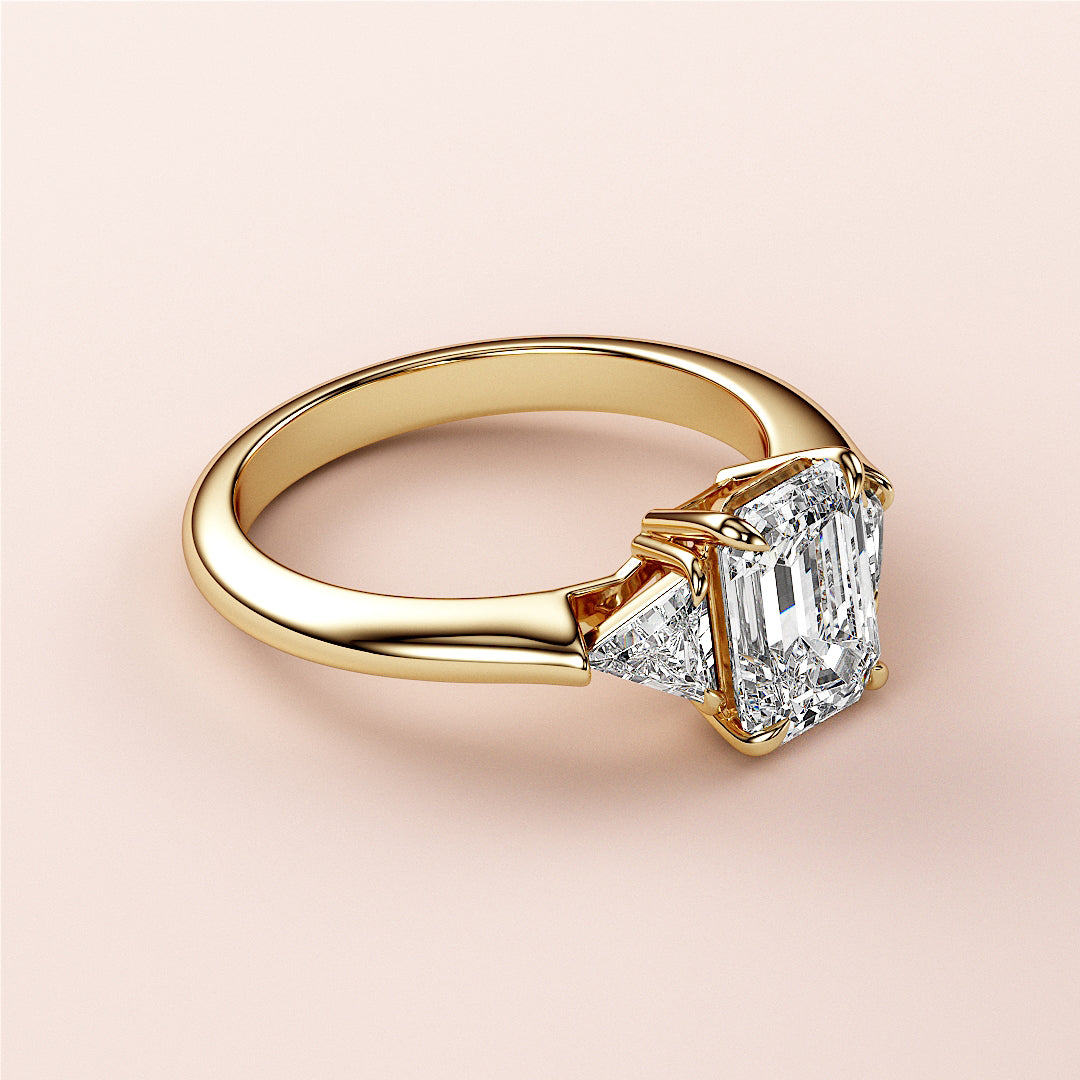 14K Gold Emerald Three-Stone Triangle Engagement Ring with Asscher-Cut Diamond and Trilliant Accents on Model's Hand
