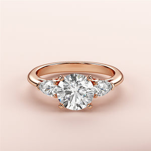 Elegant 14K rose gold engagement ring with round diamond center and two pear-shaped diamonds, perfect for timeless romance.