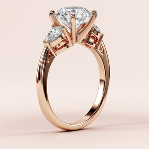 Elegant 14K/18K rose gold engagement ring with dazzling round-cut diamond and two side stones, showcasing timeless luxury.