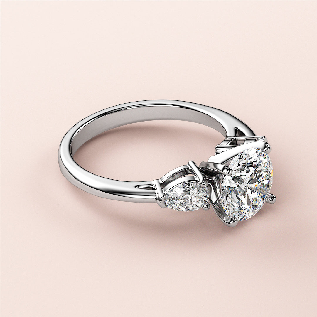 Elegant 14K white gold three-stone engagement ring with oval diamond centerpiece and pear-shaped diamonds, perfect for timeless love.
