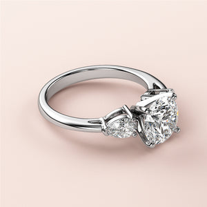 Elegant 14K white gold three-stone engagement ring with oval diamond centerpiece and pear-shaped diamonds, perfect for timeless love.