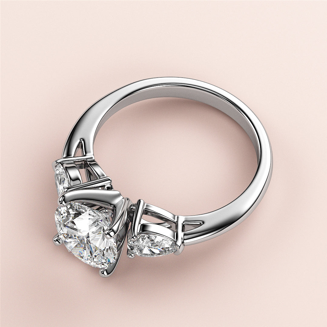 Elegant 14K/18K gold or platinum engagement ring with round-cut diamond centerpiece and two pear-shaped side diamonds.