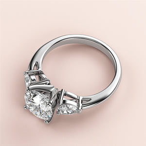 Elegant 14K/18K gold or platinum engagement ring with round-cut diamond centerpiece and two pear-shaped side diamonds.