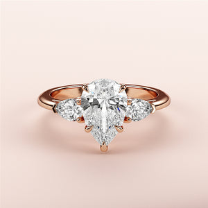 Elegant 14K or 18K rose gold pear-shaped diamond engagement ring with a central diamond and two smaller stones.