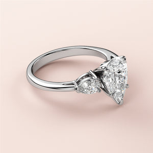Elegant 14K and 18K gold engagement ring with a pear-shaped diamond centerpiece and two smaller diamonds on a sleek band.