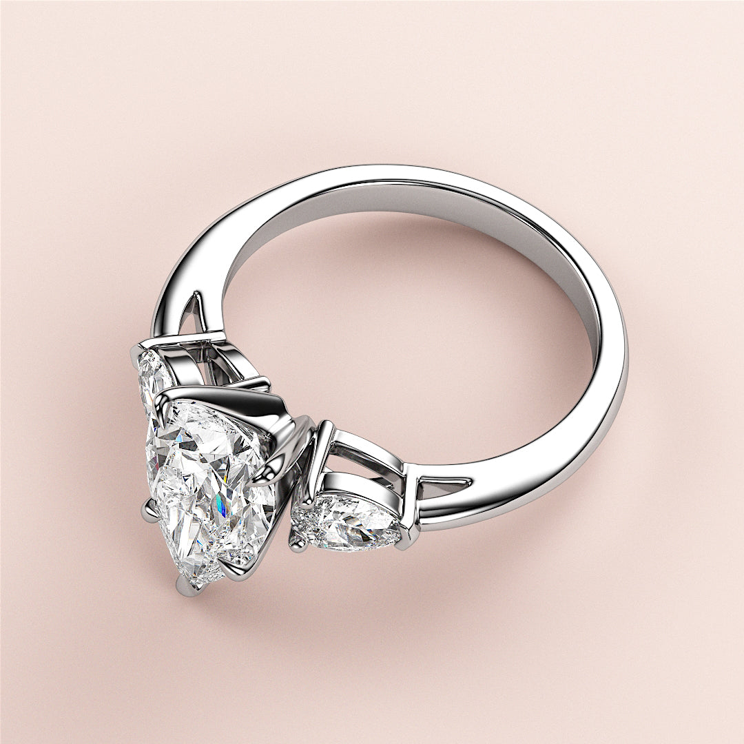 Close-up of a stunning pear-shaped diamond engagement ring with two side diamonds in 14K/18K white gold or platinum.|

#14KRecycledWhiteGold
#18KRecycledWhiteGold








#Platinum