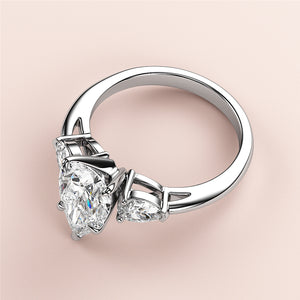 Close-up of a stunning pear-shaped diamond engagement ring with two side diamonds in 14K/18K white gold or platinum.