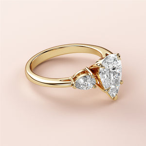 Luxurious 14K yellow gold engagement ring featuring a stunning pear-shaped diamond center stone and two smaller diamonds.