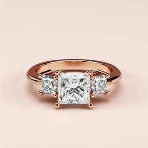Elegant 14K rose gold three-stone princess engagement ring with a radiant center diamond and dazzling side stones.