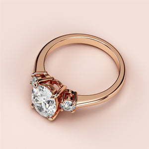 "Exquisite round diamond engagement ring in 14K rose gold, featuring a brilliant round diamond with two smaller stones for timeless elegance."