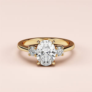 Oval-shaped engagement ring featuring two round side stones, set in 14K or 18K yellow gold or platinum band.