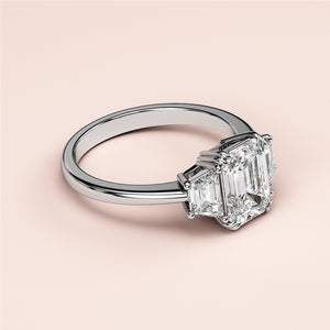 Elegant three-stone emerald cut diamond engagement ring in 14K or 18K white gold setting, perfect for timeless love.