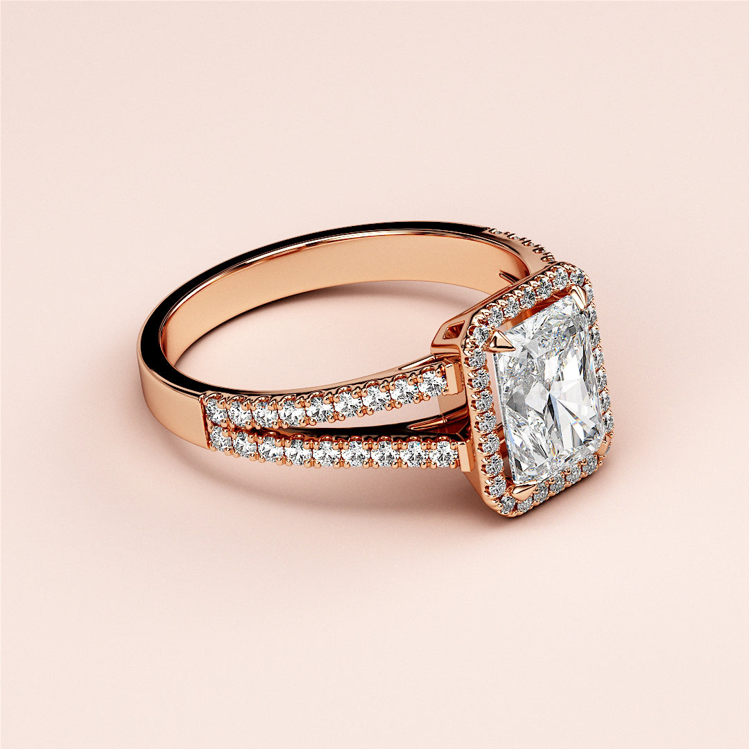 Elegant 14K Rose Gold engagement ring with radiant-cut diamond center, halo, and split shank band encrusted with diamonds.