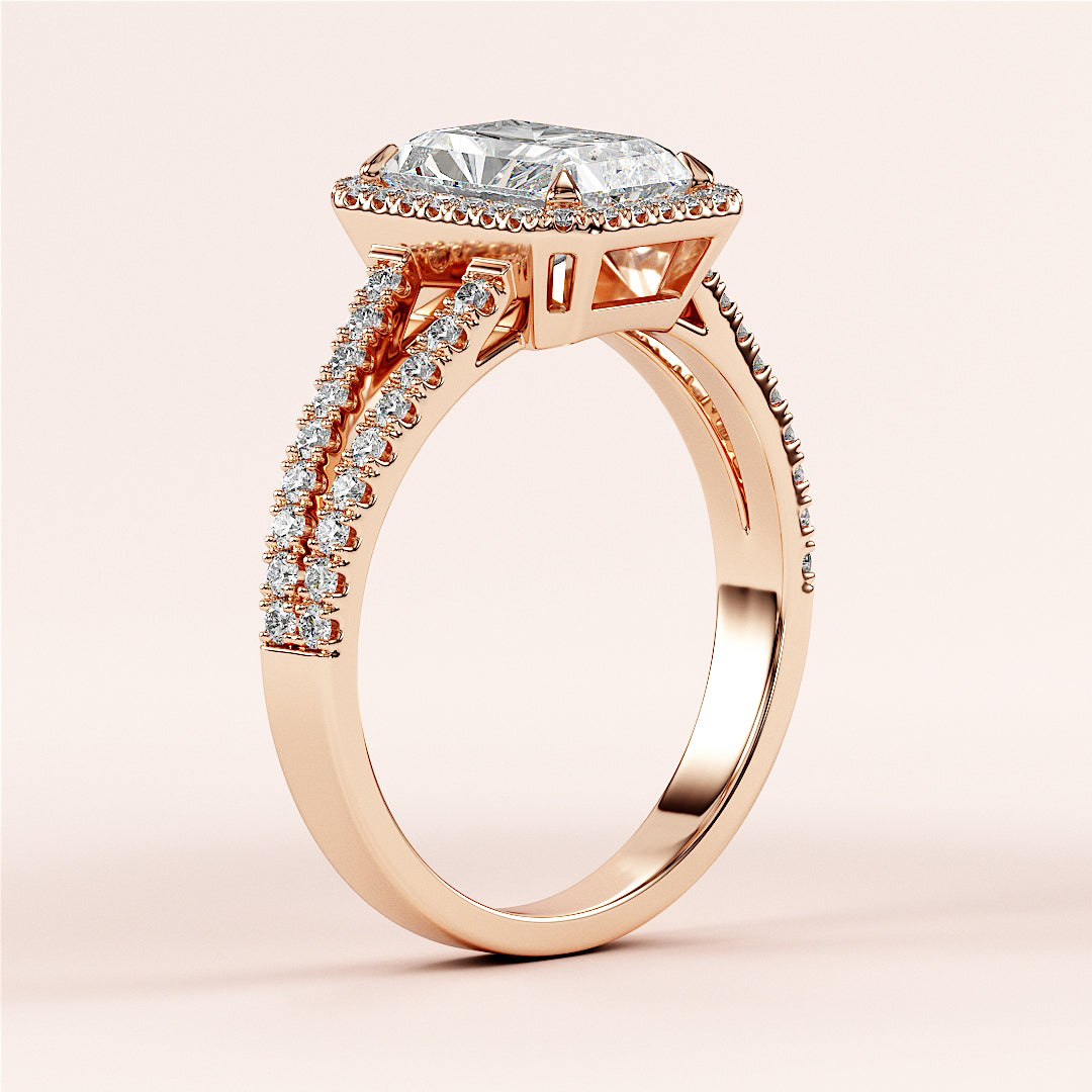 Elegant 14K or 18K rose gold engagement ring featuring a radiant halo, split shank, and emerald-cut diamond centerpiece.