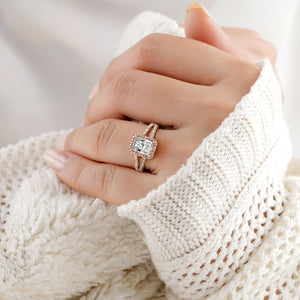 Elegant 14K rose gold ring with radiant halo and split shank, featuring an emerald-cut diamond, worn on a model's hand.