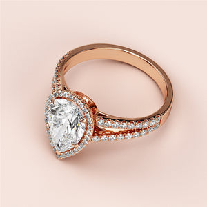 Rose gold engagement ring with pear-shaped diamond center, halo of smaller diamonds, available in 14K, 18K, or platinum.