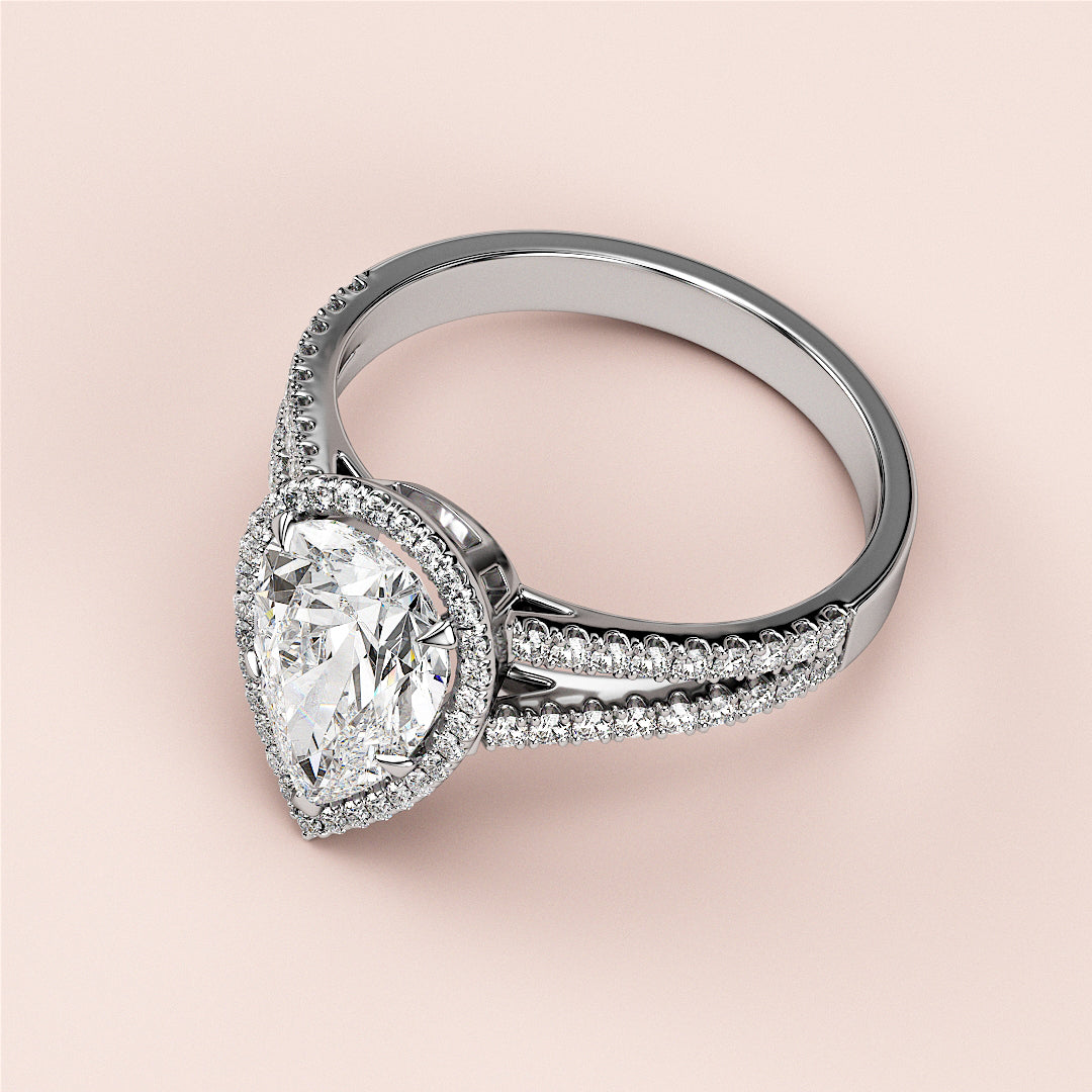 Elegant 14K White Gold pear-shaped diamond engagement ring with halo setting and pave band, displayed on soft beige background.|

#14KRecycledWhiteGold
#18KRecycledWhiteGold








#Platinum