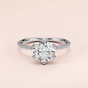 Elegant round solitaire engagement ring with accents on a pave band in 14K or 18K gold, showcasing a brilliant-cut diamond.