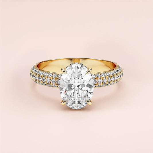 Elegant 14K yellow gold engagement ring with oval diamond and pave accents on a soft pink background. Perfect for special moments.