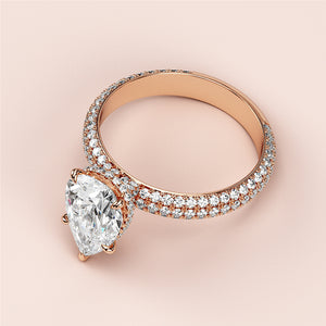 Stunning rose gold 14K pear-shaped diamond engagement ring with halo accents, featuring exquisite craftsmanship and luminous smaller diamonds.