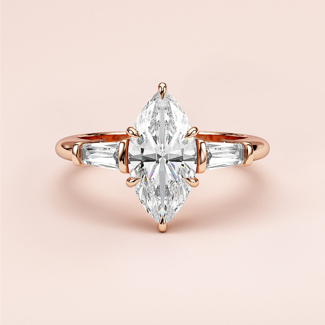 Elegant marquise diamond engagement ring with tapered baguette diamonds in 14K/18K gold or platinum on a soft pink background.