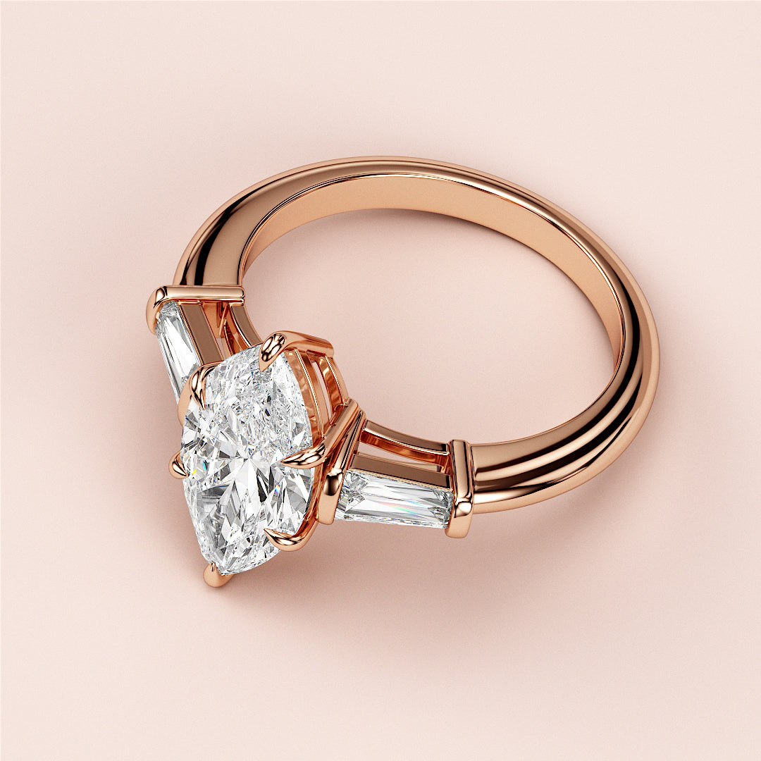 Luxury 14K rose gold engagement ring featuring a marquise three-stone design with tapered baguette side stones.
