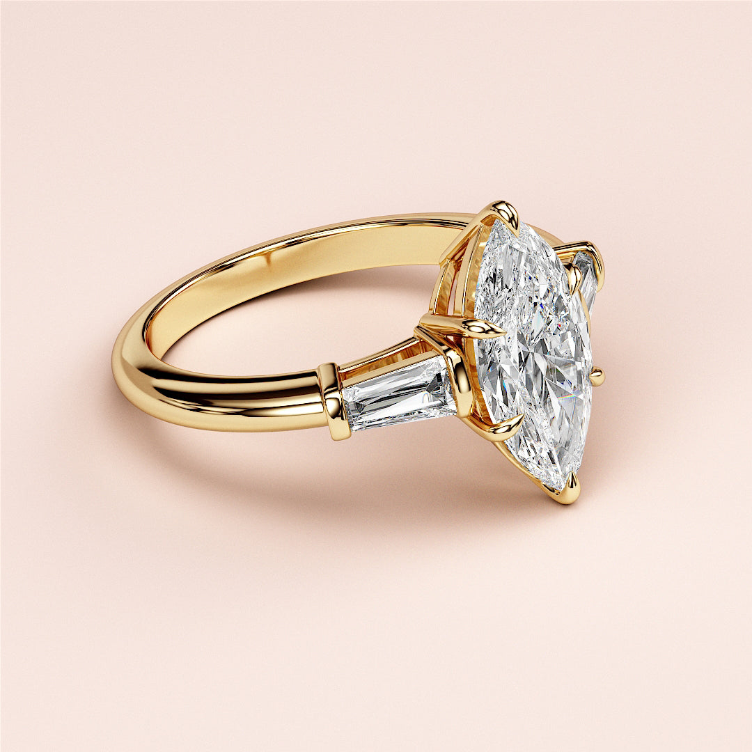 Exquisite 14K or 18K gold engagement ring featuring a marquise diamond and tapered baguette side stones on a smooth band.