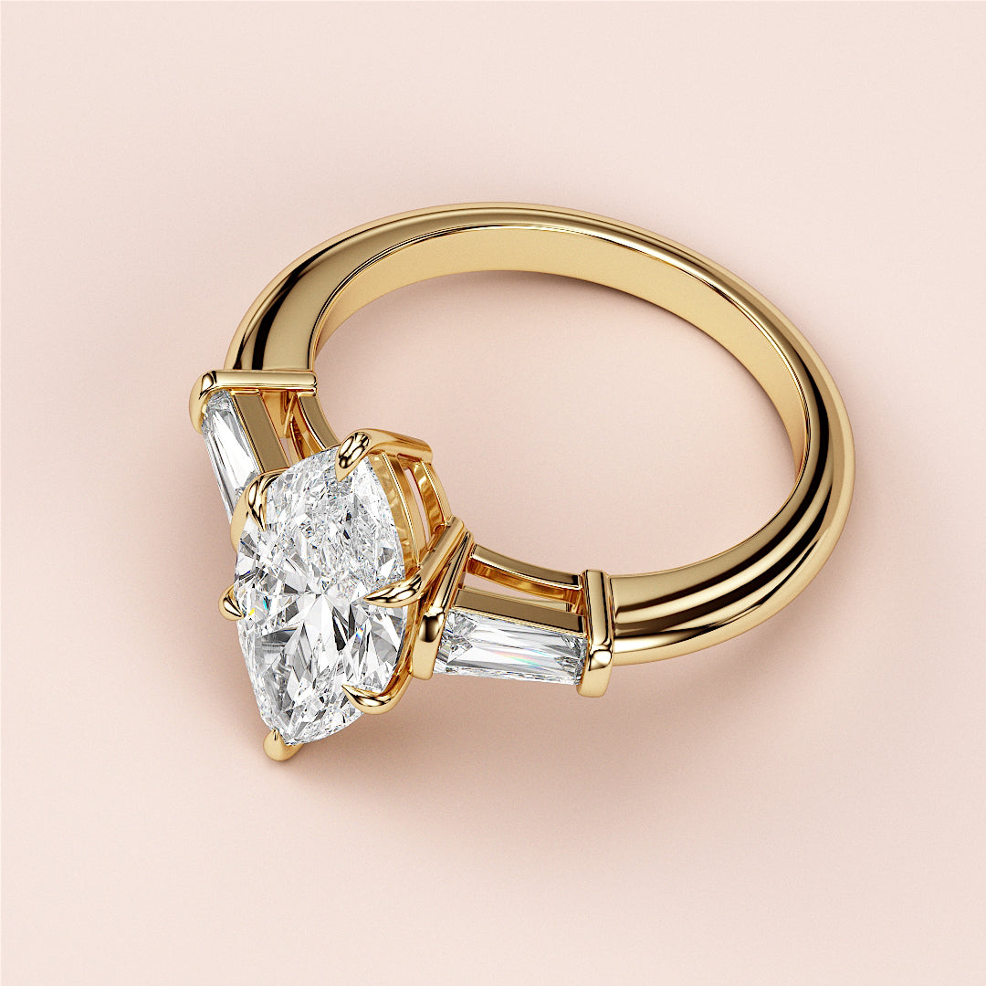 Luxury 14K yellow gold engagement ring featuring a marquise three-stone design with tapered baguette side stones.