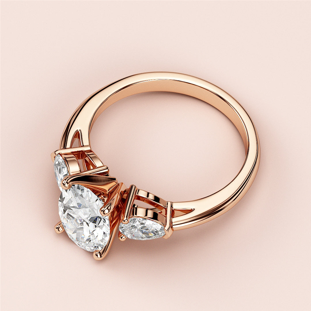 Three-stone engagement ring with oval cut diamonds in rose gold, available in 14K, 18K, or platinum.