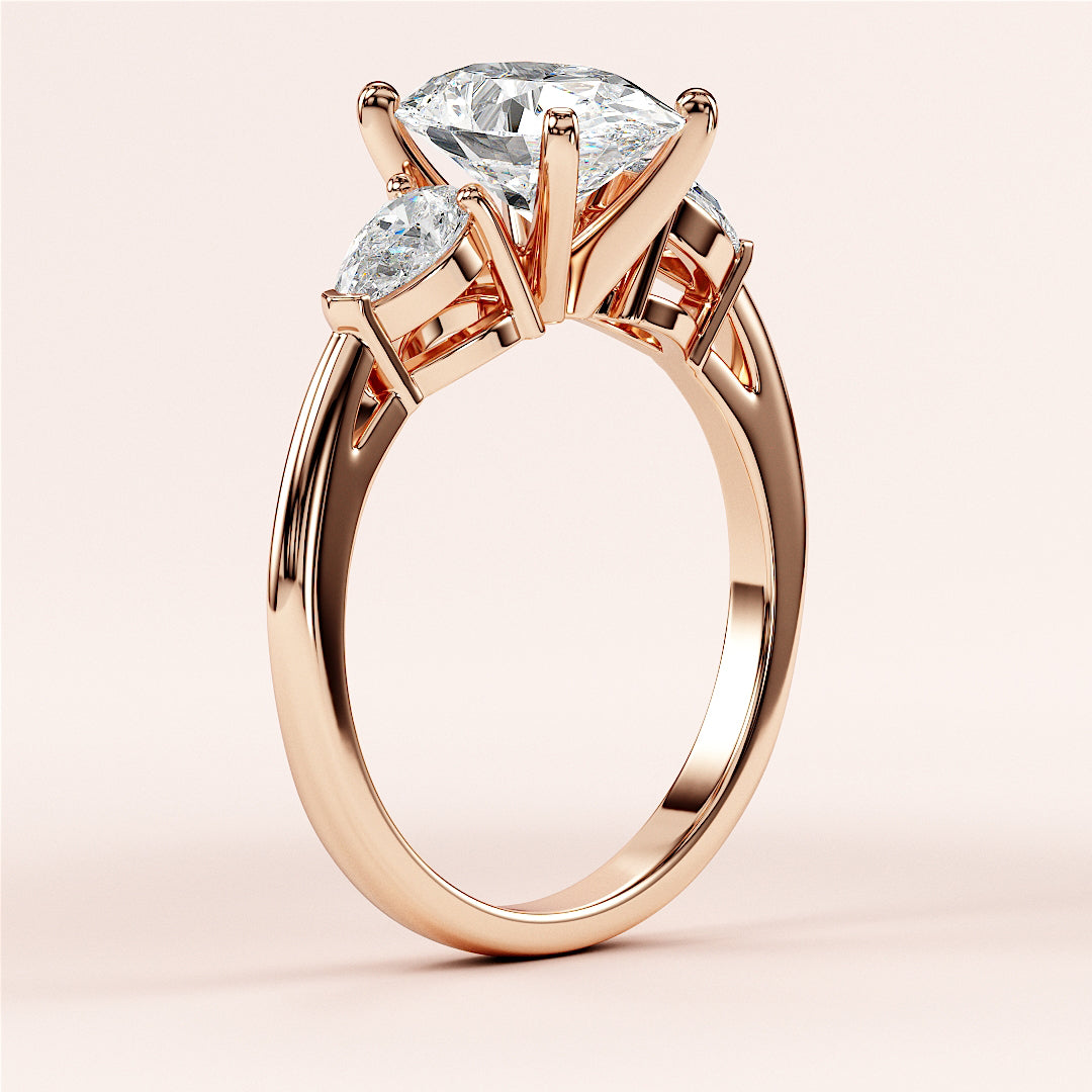 14K rose gold three-stone engagement ring with pear-shaped diamond center stone, ideal for romantic proposals.