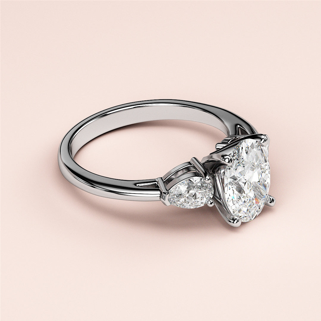 Close-up of a stunning 14K white gold engagement ring with a pear-shaped diamond and marquise-cut side stones, radiating elegance.