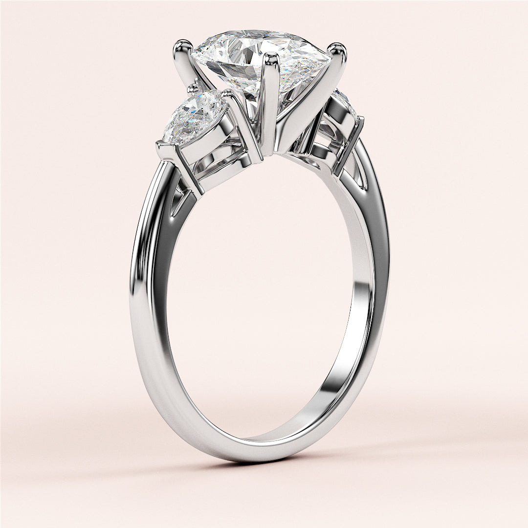 Three-stone pear-shaped diamond engagement ring in 14K gold, featuring a stunning central diamond and two flanking stones.