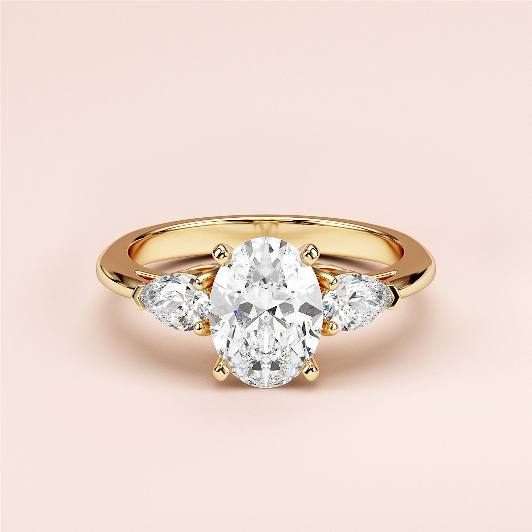 Elegant oval-shaped diamond engagement ring with two pear-shaped side stones, available in 14K or 18K gold or platinum.