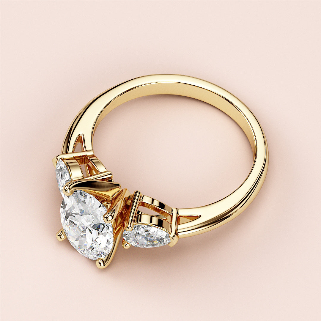 Elegant 14K gold engagement ring featuring a dazzling pear-shaped diamond with two round-cut diamond accents.
