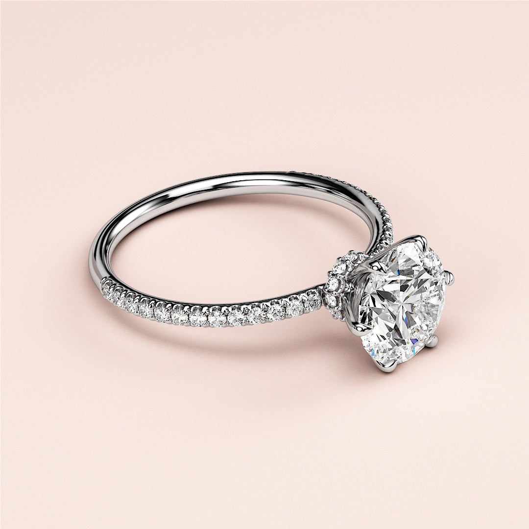 Round-cut diamond engagement ring withPave setting in 14K, 18K white gold, featuring a sparkling centerstone worn on a model.