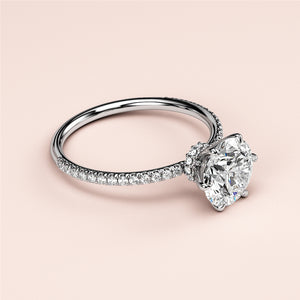 Round-cut diamond engagement ring withPave setting in 14K, 18K white gold, featuring a sparkling centerstone worn on a model.