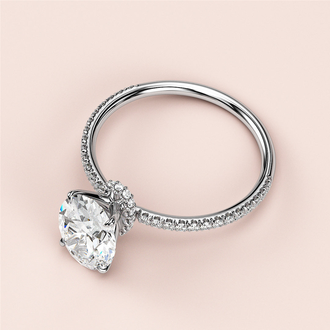 14K or 18K white gold engagement ring with a pear-shaped diamond center and round diamond accents, showcasing elegant design.