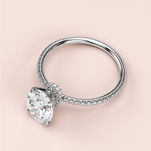 14K or 18K white gold engagement ring with a pear-shaped diamond center and round diamond accents, showcasing elegant design.