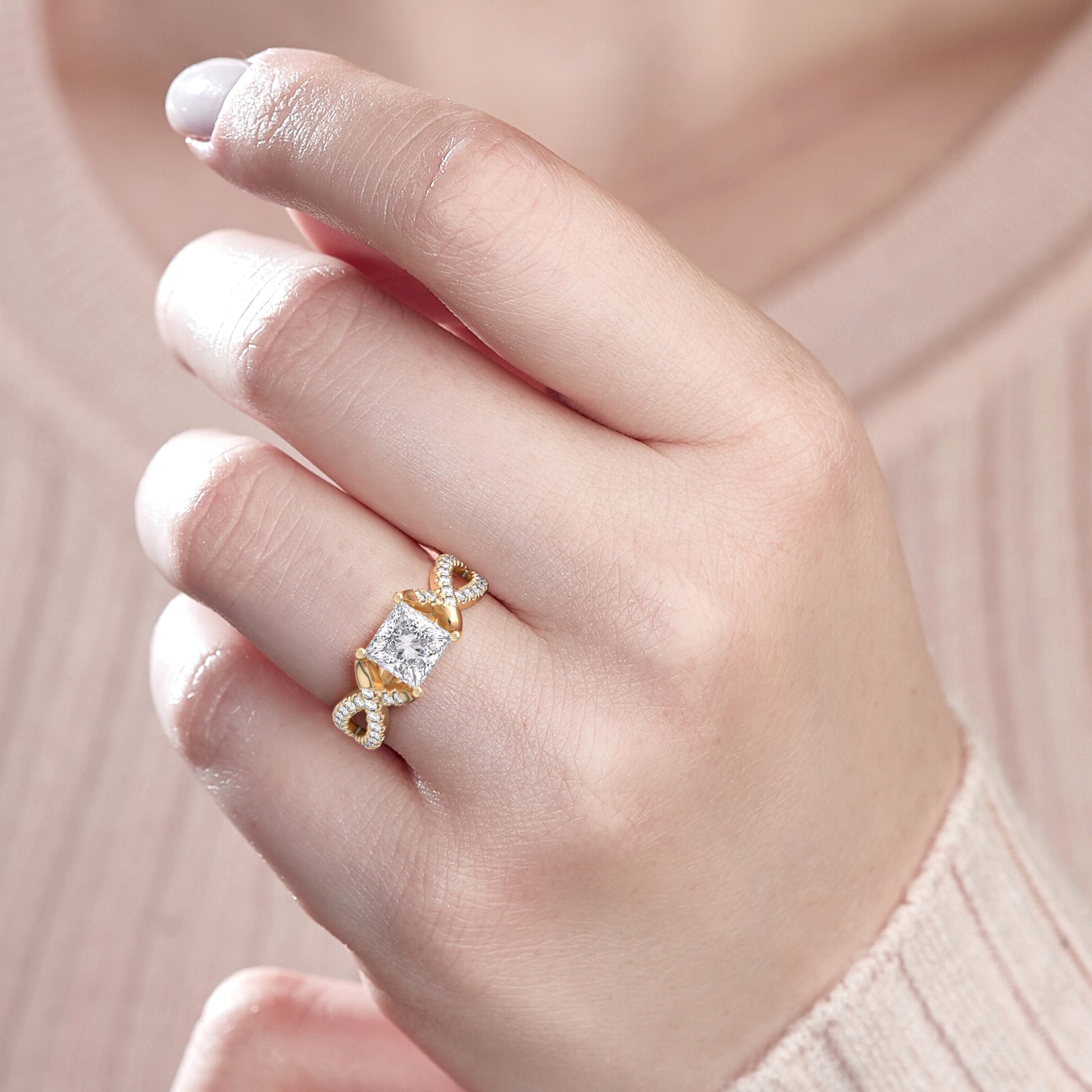 Elegant 14K gold twisted band ring with infinity design, featuring a radiant princess-cut diamond, worn by a model.|




#14KRecycledYellowGold
#18KRecycledYellowGold





