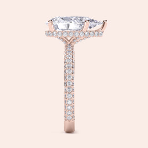 Elegant rose gold engagement ring featuring a pear shape diamond, hidden halo accents, and pave-set diamonds for added brilliance.