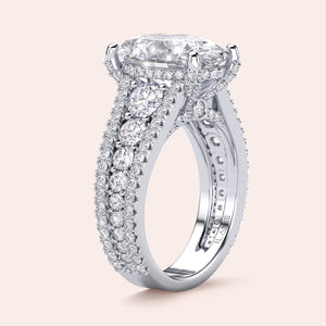 Luxurious 14K/18K white gold oval-shaped diamond engagement ring with intricate detailing and smaller diamonds along the three-row band.