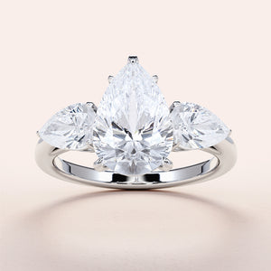 "Elegant pear-shaped diamond engagement ring with side stones, set in 14K or 18K white gold or platinum band."