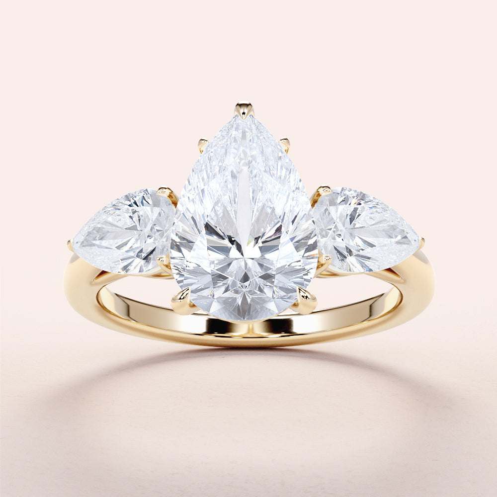 Elegant 14K yellow gold engagement ring with a pear-shaped diamond center and two side pear-shaped diamonds.