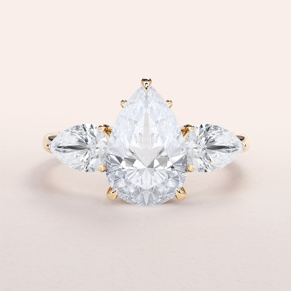 Three-Stone Pear Shaped Diamond Engagement Ring in 14K or 18K Gold or Platinum, featuring side stones for added elegance.