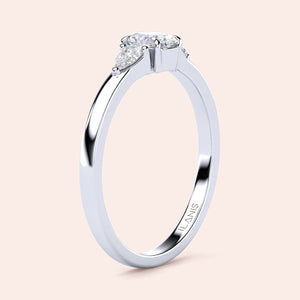 Elegant 14K white gold engagement ring featuring an oval diamond center and two pear-shaped side stones in a three-stone setting.