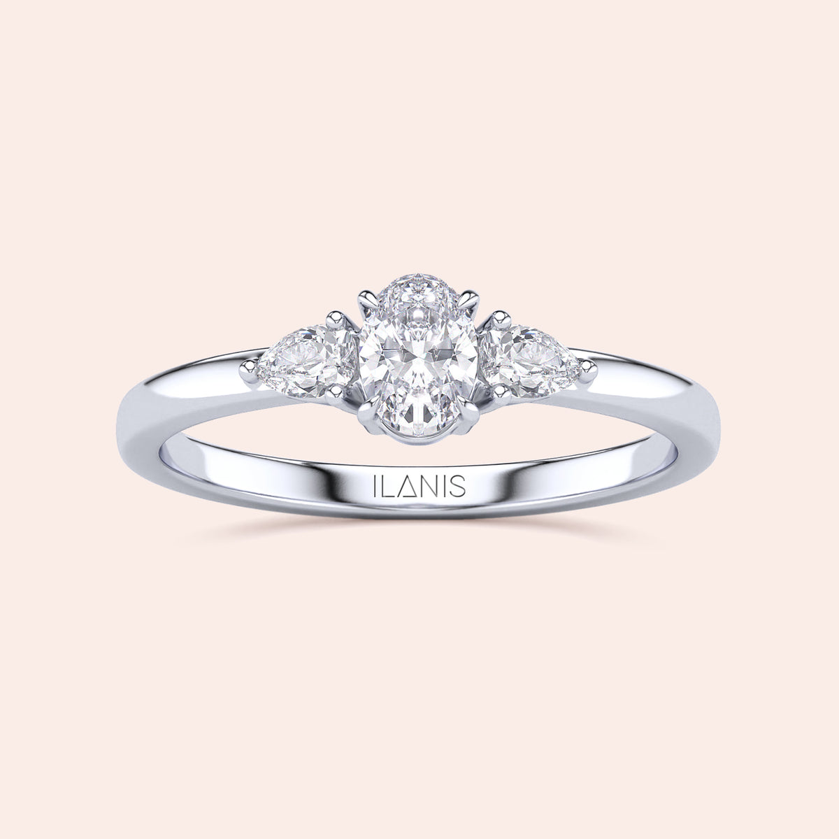Elegant 14K or 18K gold three-stone engagement ring with oval diamond and pear-shaped accents on a cream background.