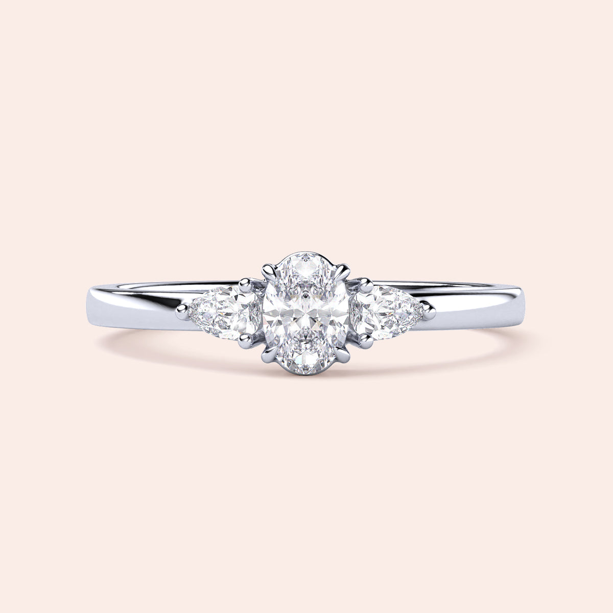 Elegant 14K white gold engagement ring featuring an oval diamond center and two pear-shaped side stones in a three-stone setting.