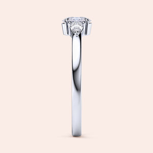 Elegant 14K white gold engagement ring featuring an oval diamond center and two pear-shaped side stones in a three-stone setting.