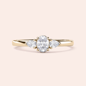 Elegant 14K or 18K gold or platinum engagement ring featuring an oval diamond and pear-shaped side stones, ideal for special occasions.