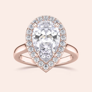 Rose gold teardrop halo engagement ring set featuring pear-shaped diamond, with options in 14K, 18K, or platinum settings.